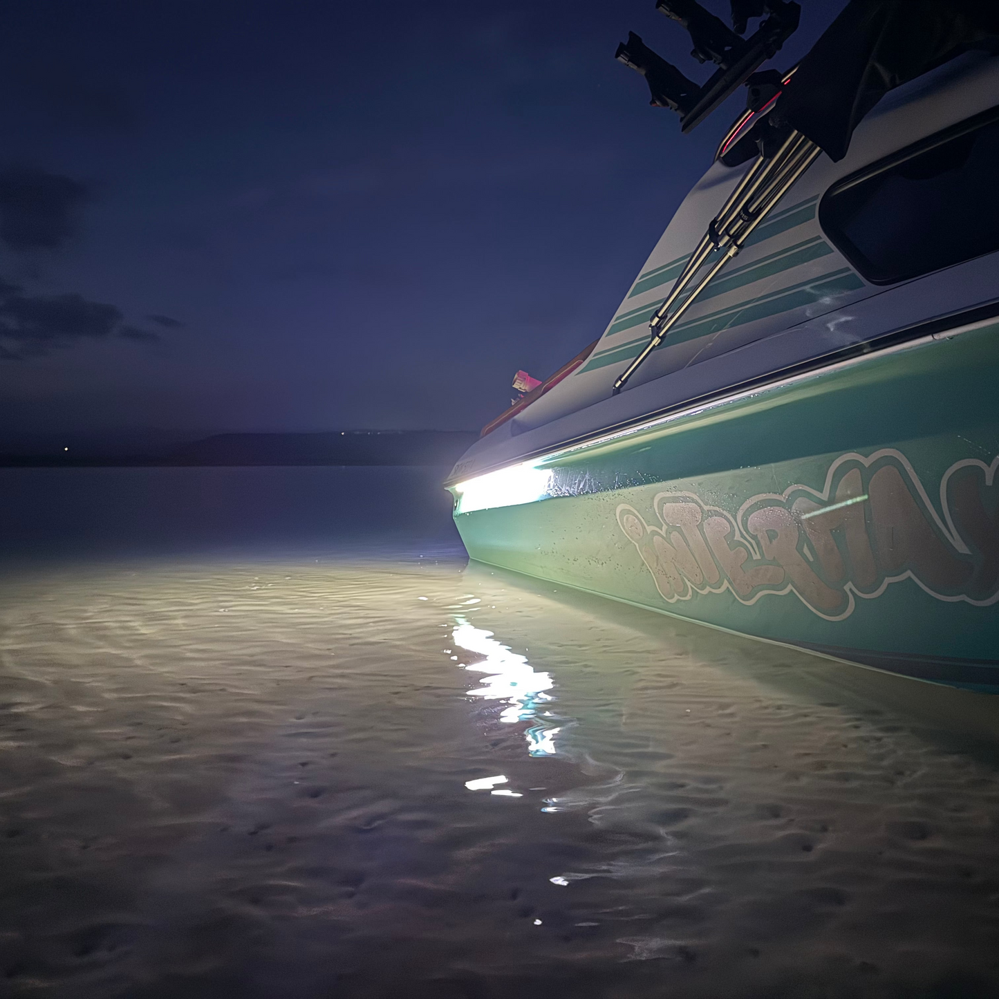 Boat on a beach at night with 'Interflax' branding.