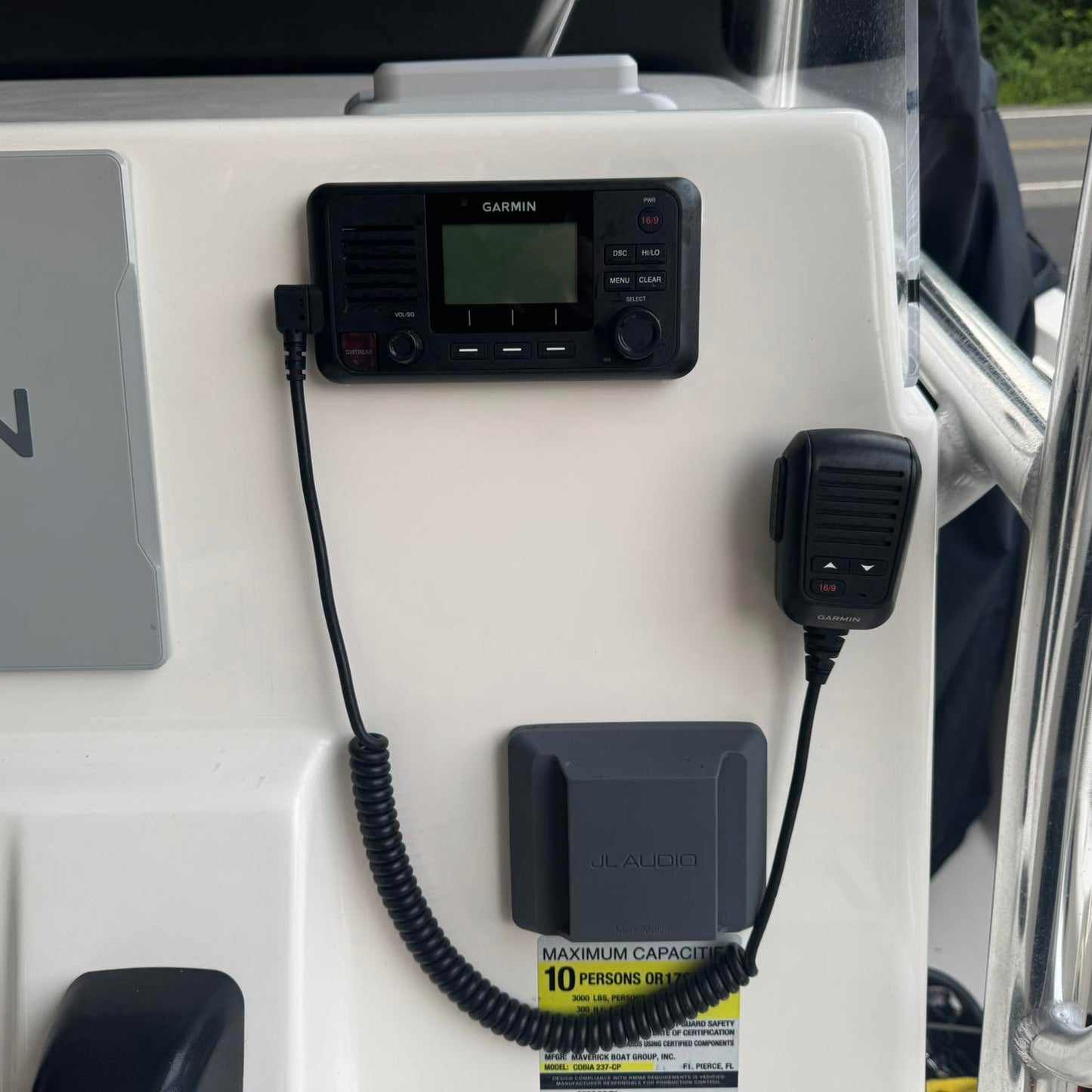 Garmin VHF 215i marine radio with GPS and DSC installed on a boat helm showing the fixed mount radio and handheld microphone