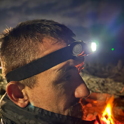 Person wearing a blast 5 led headlamp fishing with a fire in the background