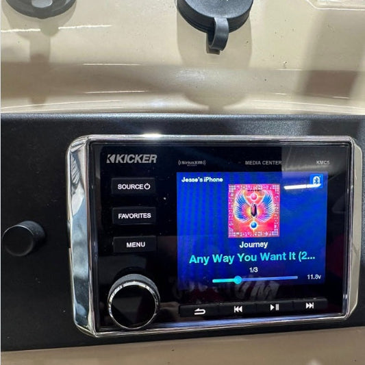 Kicker car stereo system with media player displaying a song on a screen.