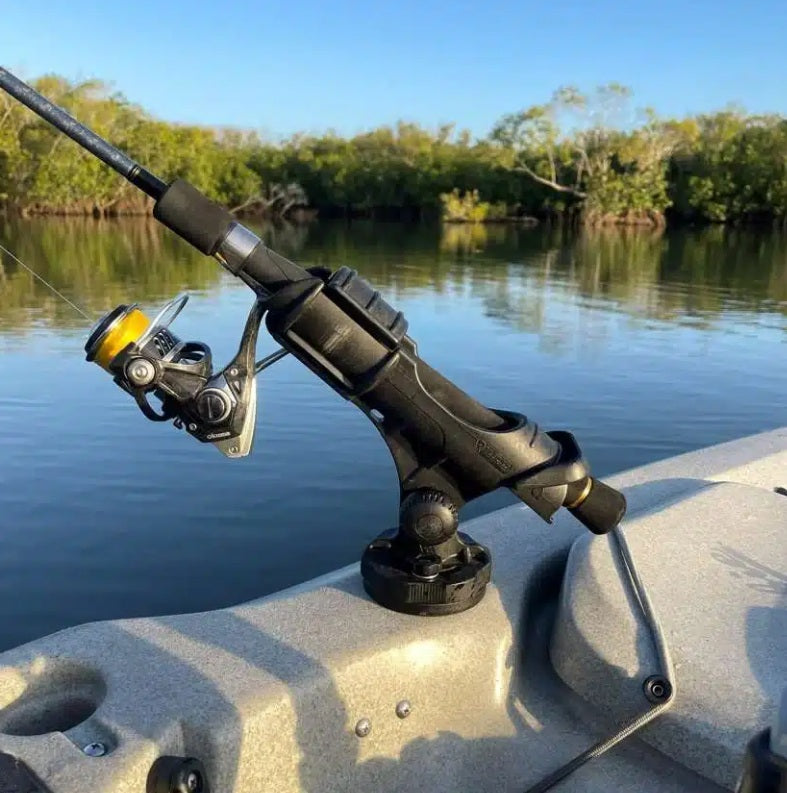 Fishing rod and reel on a boat with a body of water and trees in the background