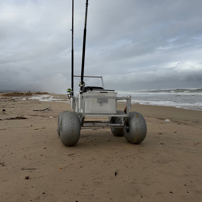 Front view of Tidal Hook beach fishing cart with oversized balloon wheels, rod holders, and storage crate designed for easy transport of surf fishing gear.