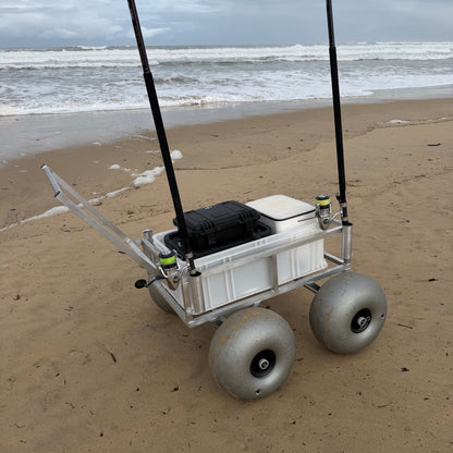 Tidal Hook beach fishing cart with oversized balloon wheels, rod holders, and storage box for transporting fishing gear across soft sand.