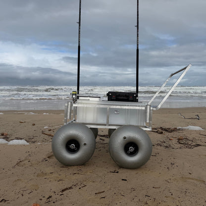 Tidal Hook beach fishing cart with oversized balloon wheels, rod holders, and storage compartment designed for easy transport across soft sand.