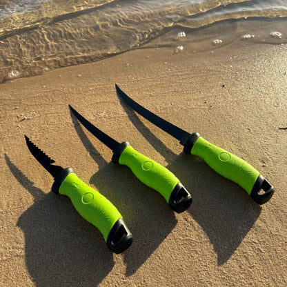 Three black fillet knives with bright green handles displayed on a sandy beach, designed for precision fish cleaning and filleting.