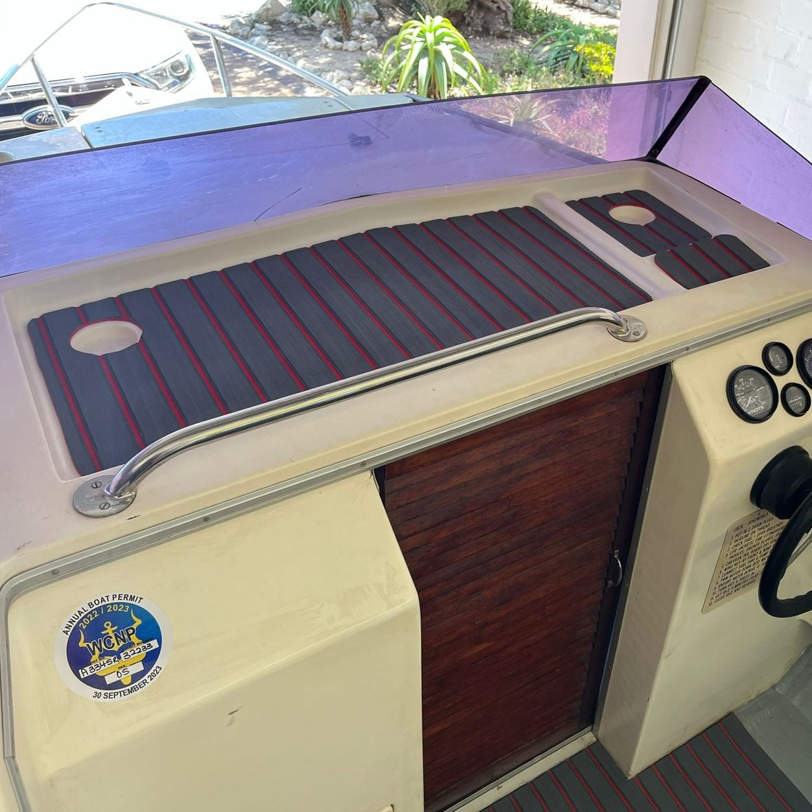 Grey and red EVA decking installed on a boat dashboard and cockpit flooring