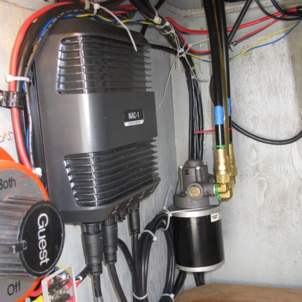 Installed marine air horn compressor and control module mounted inside a boat compartment with electrical wiring and air hose connections.