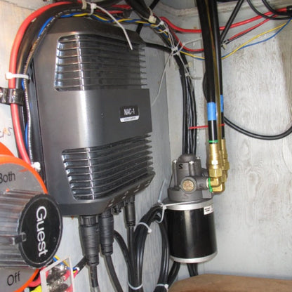 Installed marine air horn compressor and control module mounted inside a boat compartment with electrical wiring and air hose connections.
